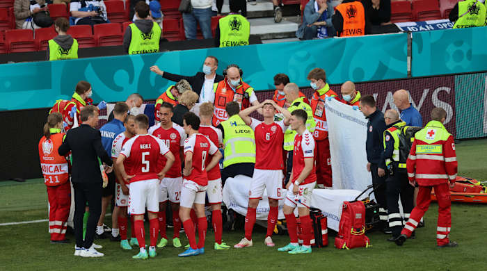 Christian Eriksen is surrounded by his Denmark teammates after he collapses on the field.